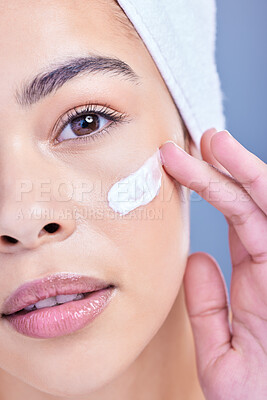 Buy stock photo Closeup portrait of a beautiful young mixed race woman applying cream to her face. Hispanic model with glowing skin using sunscreen on her skin