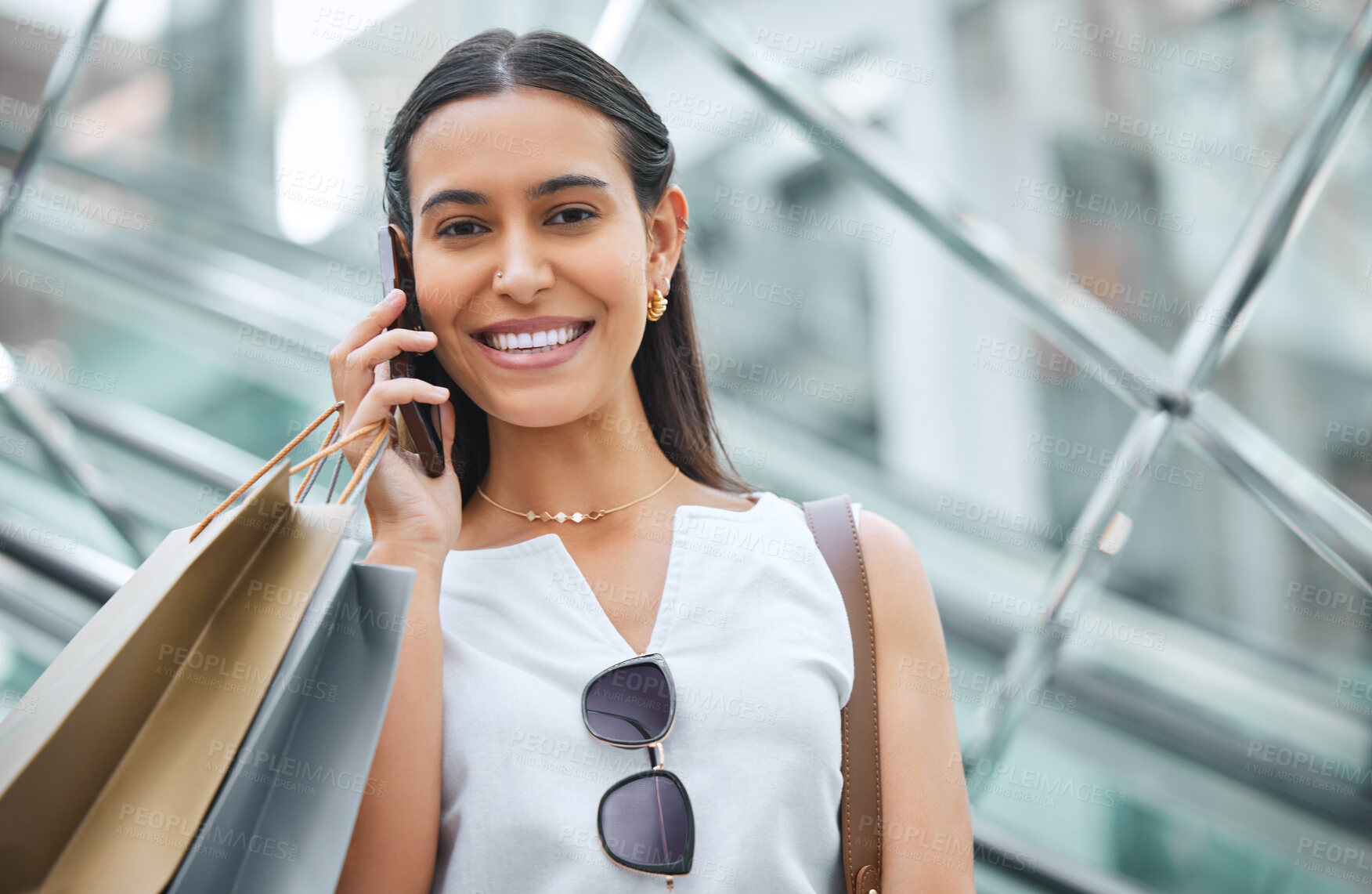 Buy stock photo Phone call, face and a woman with a shopping bag on mall escalator for fashion, sale or discount deal. Portrait of female person or happy customer talking on smartphone for retail promotion chat