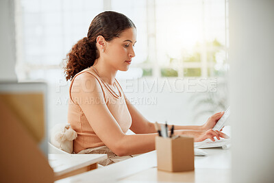 Buy stock photo One young hispanic business woman using a calculator while working on a computer in an office. Focused entrepreneur calculating finances for tax, online banking and budget expenses