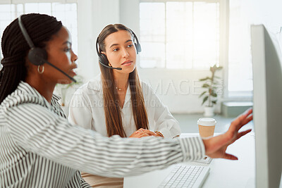 Buy stock photo Young hispanic call centre telemarketing agent discussing plans with a colleague while working together on a computer in an office. Consultants troubleshooting solution for customer service and sales support