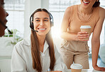Group of confident call centre telemarketing agents and operators having a discussion together. Cheerful hispanic woman drinking coffee while talking to her colleagues during a break in an office