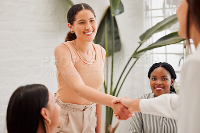 Buy stock photo Confident young hispanic businesswoman shaking hands with colleague during a meeting in an office. Motivated woman looking happy after receiving a successful promotion, deal and merger. Coworkers greeting while collaborating in a creative startup agency