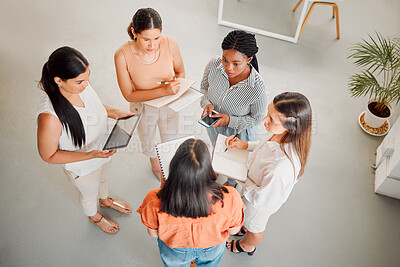 Buy stock photo Diverse group of five businesswomen having a meeting together in at work. Serious businesspeople talking and planning while standing in an office from above