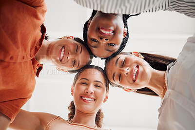 Buy stock photo Portrait of happy businesswomen joining their heads together in a circle in an office at work. Diverse group of cheerful businesspeople having fun standing with their heads together in unity