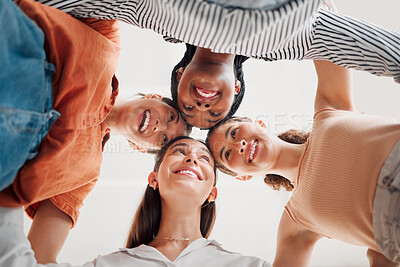Buy stock photo Group of happy businesswomen joining their heads together in a circle in an office at work. Diverse group of cheerful businesspeople having fun standing with their heads together in support