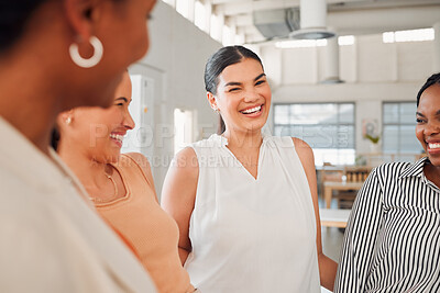 Diverse group of happy businesswomen having a meeting together in at work. Joyful businesspeople talking and laughing while standing in an office