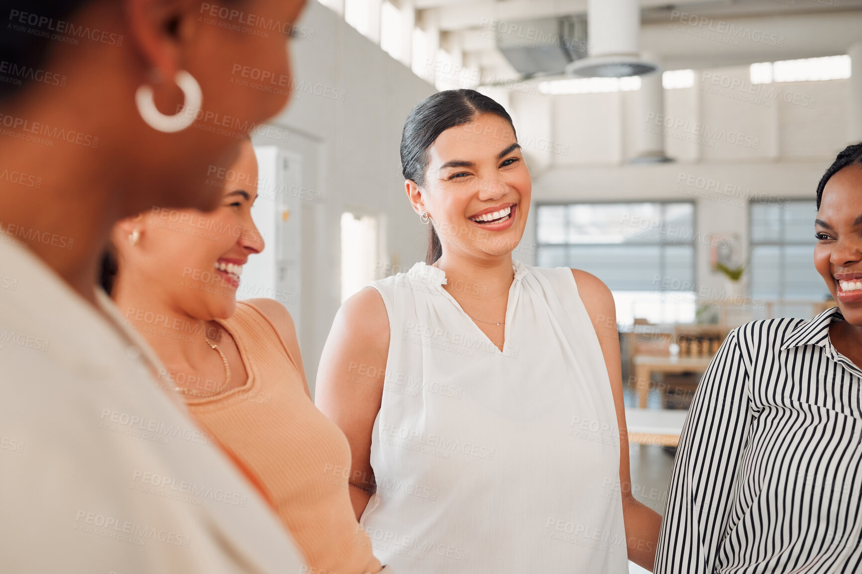 Buy stock photo Diverse group of happy businesswomen having a meeting together in at work. Joyful businesspeople talking and laughing while standing in an office