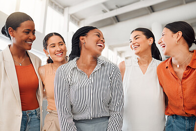 Diverse group of five happy businesswomen having a meeting together in at work. Joyful businesspeople talking and laughing while standing in an office