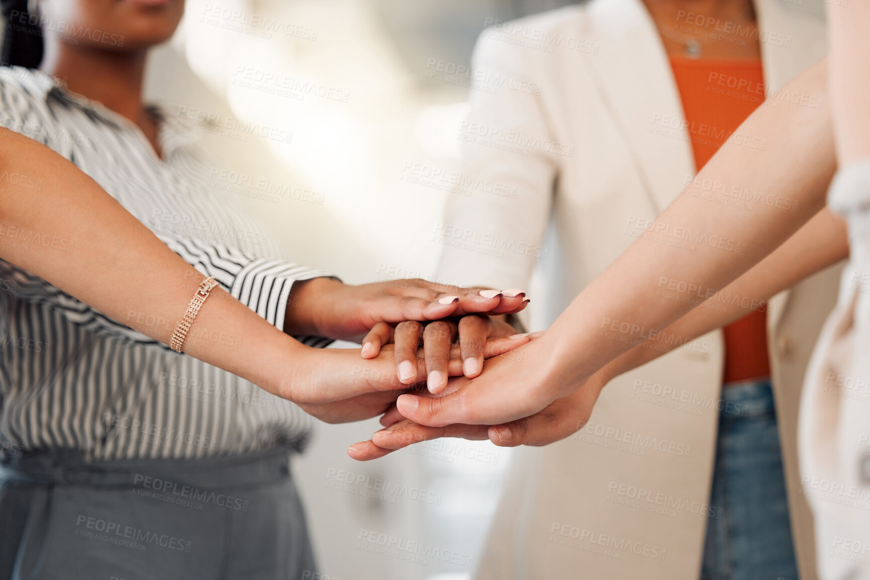 Buy stock photo Group of businesswomen stacking their hands together in an office at work. Diverse group of businesspeople standing with their hands stacked for motivation