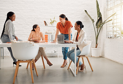 Buy stock photo Diverse group of happy businesswomen having a meeting together in a boardroom at work. Joyful businesspeople talking while planning and using a laptop in a workshop in an office