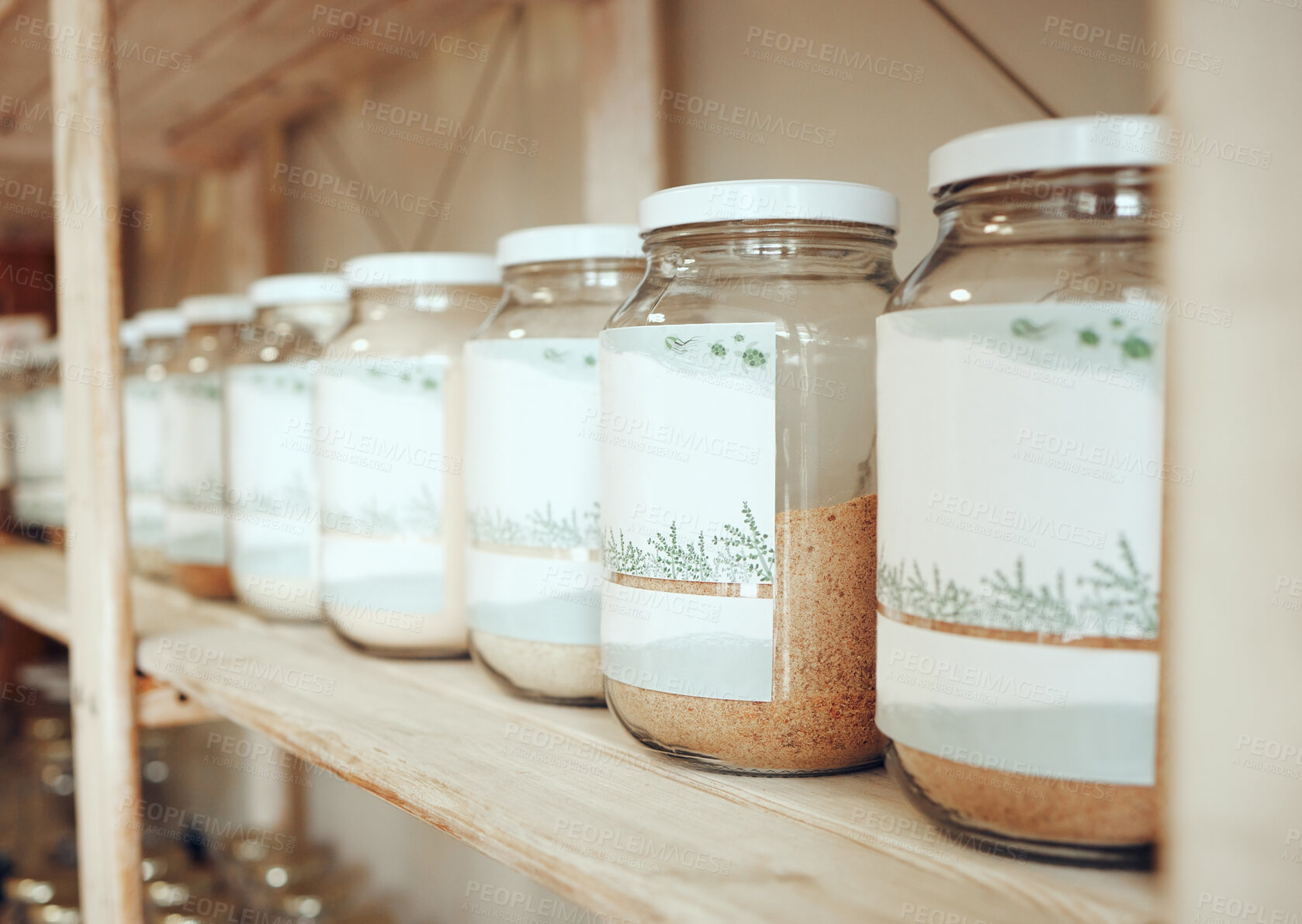 Buy stock photo Glass jars of spices lined up in a row on a display shelf in a grocery store. Fresh produce from the farmer's market. Get to your local green grocer for all your cooking, spice and flavouring needs