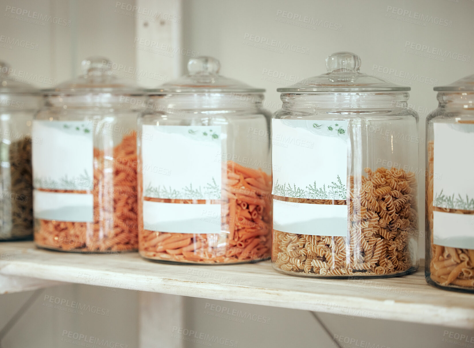 Buy stock photo Glass jars of different types of pasta lined up in a row on a display shelf in a grocery store. Get to the local grocer for all your cooking needs. Every chef needs a variety of pasta in their kitchen