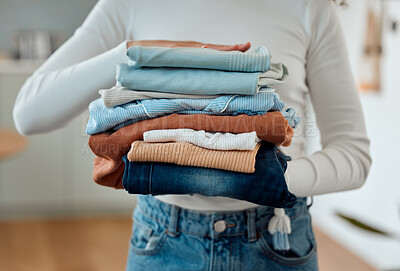 Buy stock photo hands of a woman holding a pile of laundry. Woman holding a stack of neat, folded laundry. Woman cleaning clothing at home. Woman carrying a pile of fresh, cleaned clothing at home