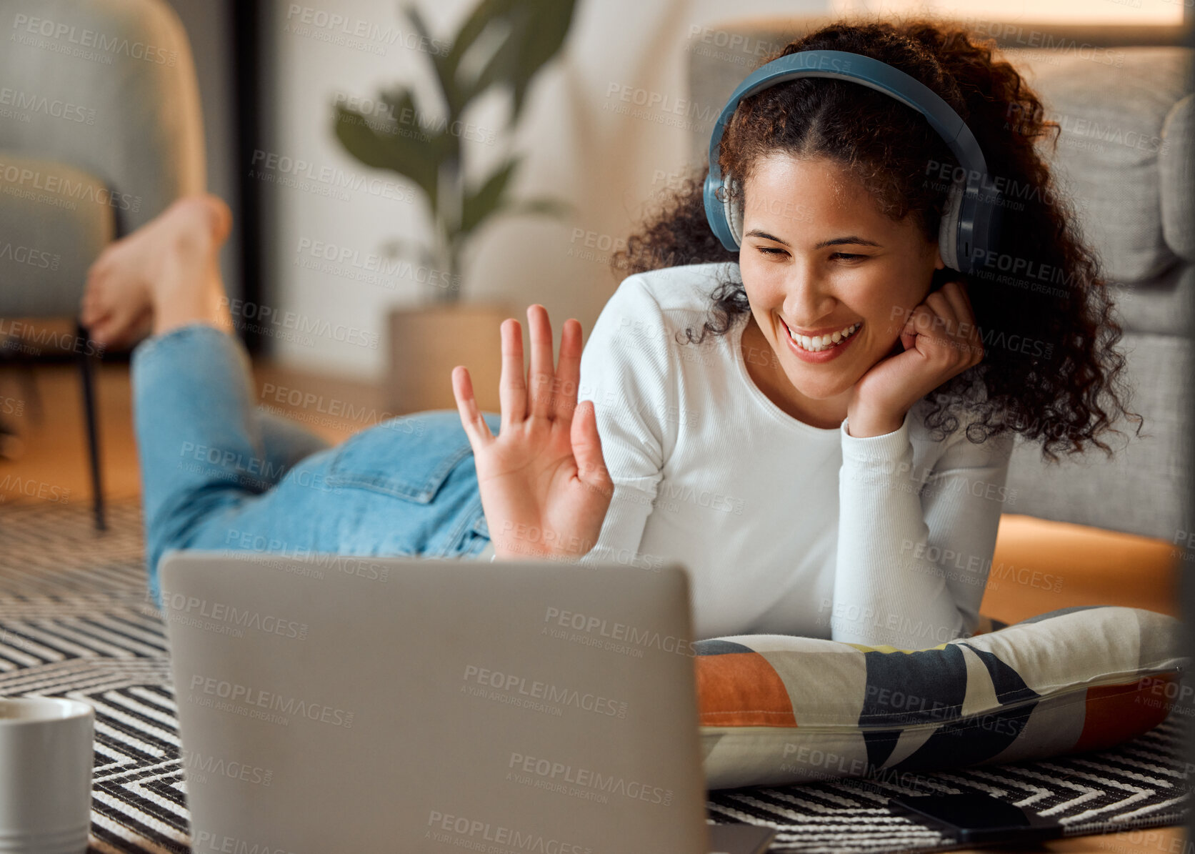 Buy stock photo Young woman waving during a video call. Young woman making a video conference on her laptop. Happy woman using headphone for a video call. Woman greeting during a video conference on her computer