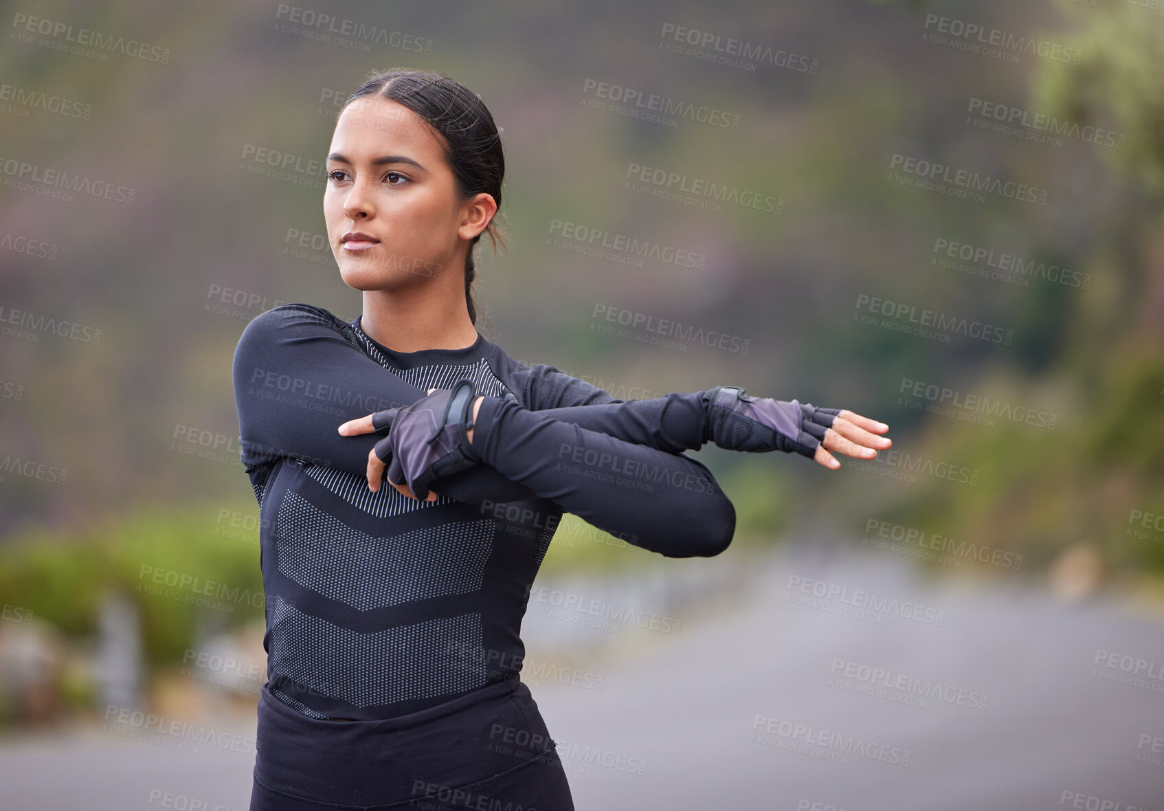 Buy stock photo Young mixed race hispanic female stretching before a run outside in nature. Exercise is good for your health and wellbeing. Stretching is important to prevent injury and sore muscles