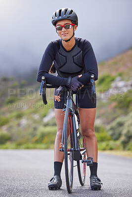 Beautiful, athletic, mixed race young woman exercising outside in the forest. Healthy and sporty female athlete out for a cycle in the wilderness. Endurance and cardio during a workout in the woods