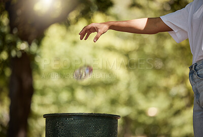 Buy stock photo Closeup shot of a woman throwing her plastic cooldrink bottle into a bin outside in a park. The planet is our home, recycling is our responsibility. Saying goodbye to pollution and trash. Your environment is important let's protect it
