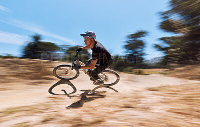 Buy stock photo Young man showing his cycling skills while out cycling on a bicycle outside. Adrenaline junkie practicing a speed cycling outdoors. Male wearing a helmet doing tricks with a bike. Extreme sports