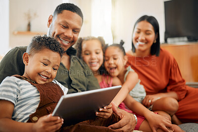 Buy stock photo A happy mixed race family of five relaxing on the sofa at home. Loving black family being affectionate on the sofa while using a digital tablet and streaming. Young couple bonding with their kids and watching movies at home