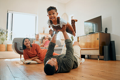 Buy stock photo A happy mixed race family of five relaxing in the lounge and being playful together. Loving black family bonding with their son while playing fun games on the floor at home