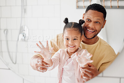 Buy stock photo Happy mixed race father and daughter washing their hands  together in a bathroom at home. Single African American parent teaching his daughter about hygiene while having fun and being playful