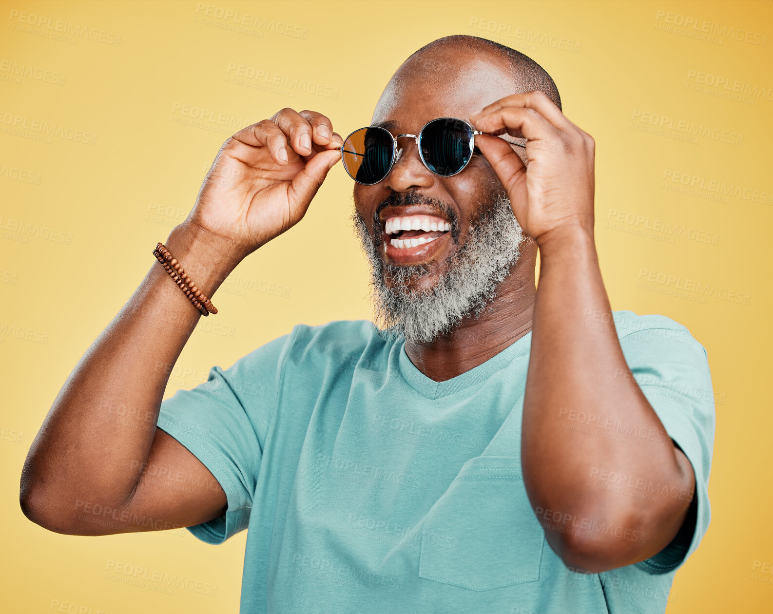 Buy stock photo Happy mature African American man standing alone against yellow background in a studio and posing with sunglasses. Smiling black man feeling fashionable and cool while wearing glasses. Summer ready