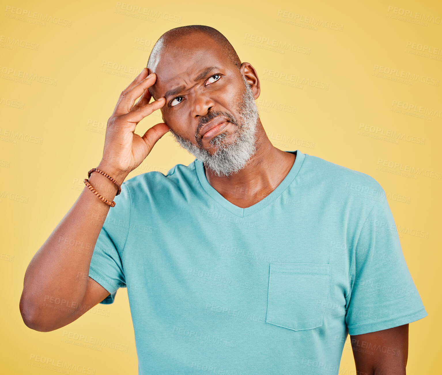 Buy stock photo Confused mature African american man with grey beard and casual clothes looking up while thinking or wondering about question while standing against yellow background