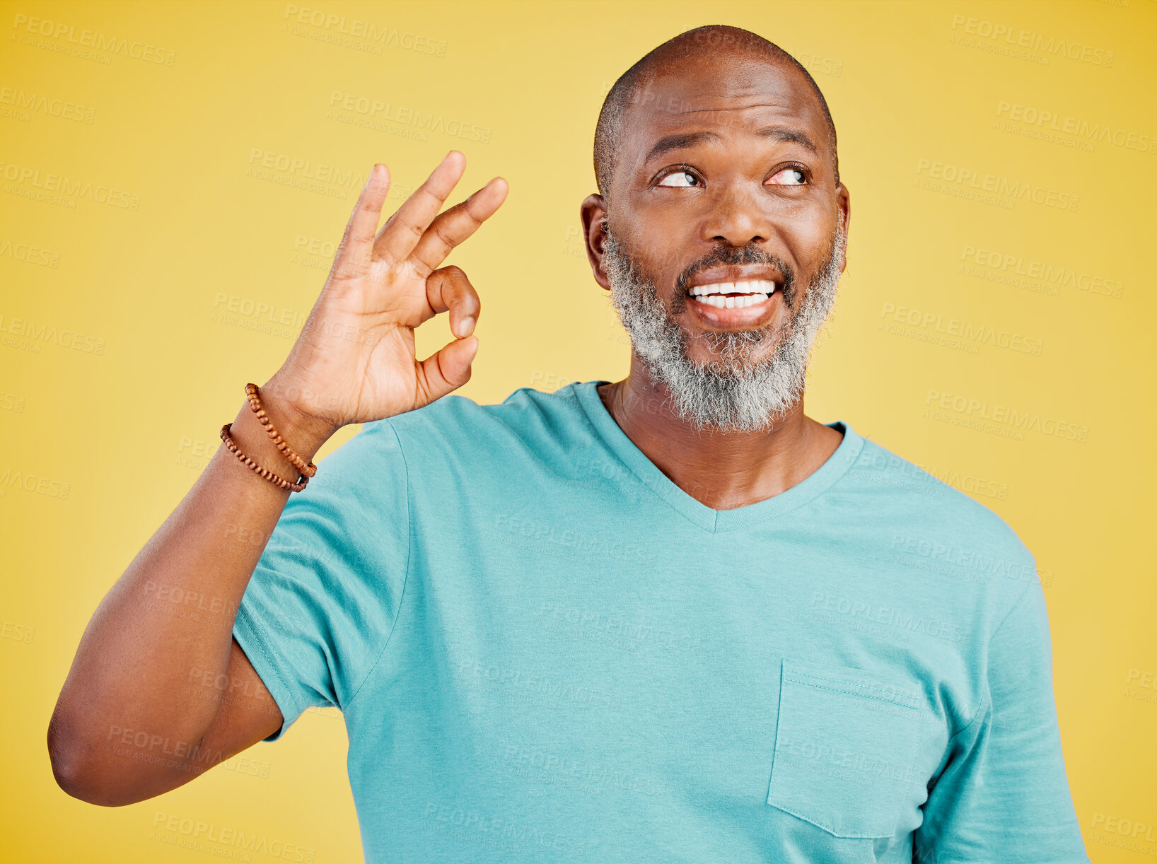 Buy stock photo Mature african american man smiling while making an okay gesture with his hand against a yellow studio background. Expressing that everything is perfect. Showing support