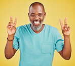 Portrait of a mature friendly african american man looking happy and smiling while making an peace gesture with both his hands against a yellow studio background. Expressing that everything is perfect. Showing support