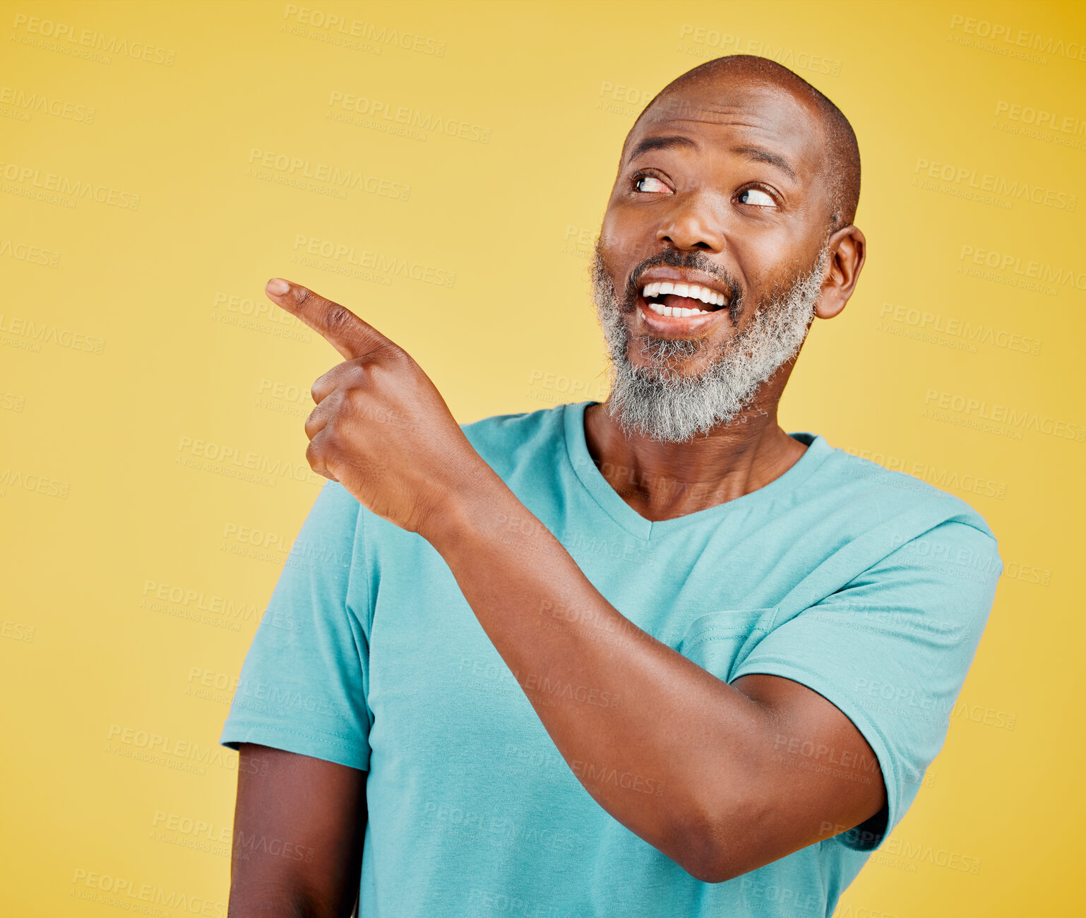 Buy stock photo Mature african man smiling and pointing in a direction against a yellow studio background. Black guy looking happy and making a pointing gesture reacting with smile while looking cheerful and happy. Stay positive you never know what's coming next