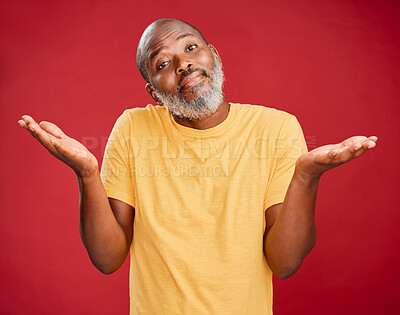 Buy stock photo Mature african american man with a beard shrugging his shoulders and making a gesture with his hands standing against a red studio background. Uncertain, decision, choice
