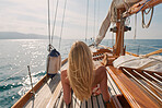 Blonde woman lying on a boat sunbathing enjoying a cruise. Young woman on a cruise lying on boat. Blonde woman sunbathing on a boat enjoying the sun