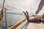 Legs of sexy woman in white bikini lying on boat sunbathing. Woman in white bikini tanning legs on a boat. Sexy legs of woman wearing white bikini sunbathing on a cruise