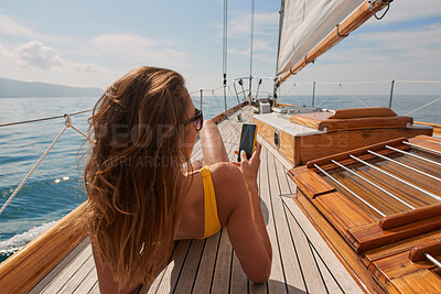 Buy stock photo Travel, ocean and women with phone on boat relax for cruise on holiday, vacation and adventure at sea. Luxury sailing, sunbathing and female person on smartphone for social media, memories and text