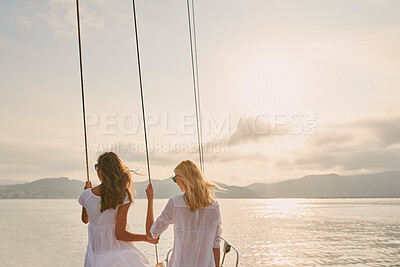 Buy stock photo Two friends on holiday cruise together holding rigging cables enjoying the sunset. Two women enjoying the sunset together holding boat rigging cables