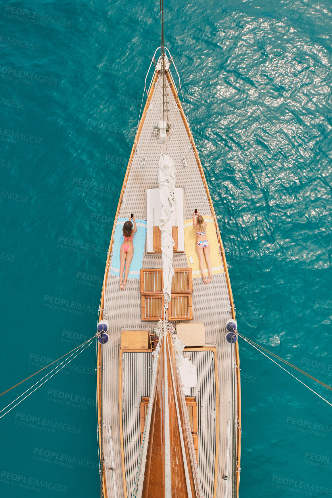 Buy stock photo Aerial, ocean and women with phone on boat relax for cruise, luxury sailing and transport on sea. Social media, travel and female people on yacht for tropical journey, sunbathing and tourism on water