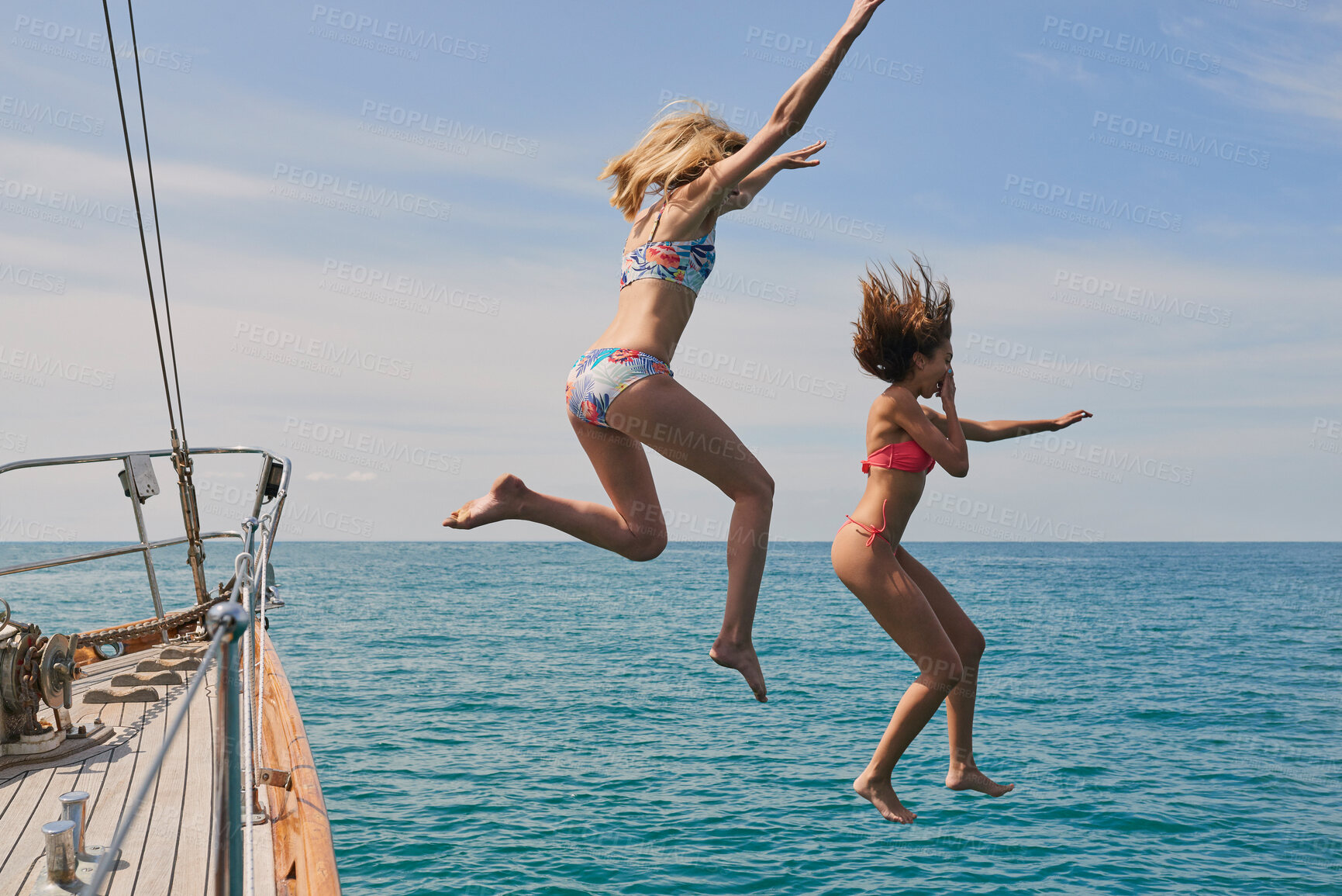 Buy stock photo Travel, sailing and friends jumping off a yacht together into the ocean for freedom, fun or swimming. Summer, energy and bikini with girls leaving a boat to jump into the sea while on a luxury cruise