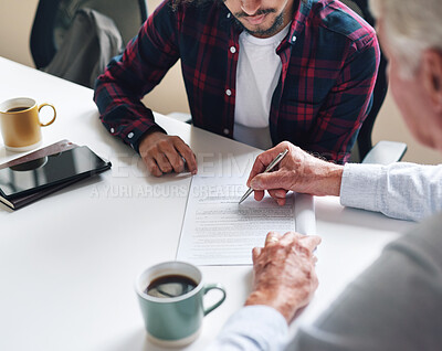Buy stock photo Financial advisor helping young man sign investment contract. Two men in a meeting discussing a contract to be signed. Senior accountant helping young man sign contract