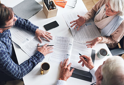 Buy stock photo A mature businessman and businesswomen planning contracts with their coworker. A senior couple meeting their banker to discuss and plan their retirement from above. A mature couple signing contracts