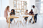 Group of diverse businesspeople having a meeting at a table in an office. Business professionals talking and planning together at work. Male and female colleagues working at a table