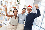 Portrait of three joyful businesspeople celebrating at a festive party together at work. Happy colleagues looking cheerful at a christmas office party. Coworkers celebrating the holiday season