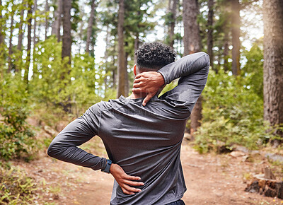 Buy stock photo Unrecognizable mixed race hispanic male stretching before a run while experiencing some back and neck pain in a forest. Exercise is good for your health and wellbeing. Stretching is important to prevent injury and muscle strain