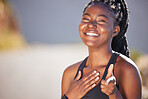 A beautiful young african american woman looking confident and gesturing towards the camera outside. A female athlete looking happy and positive while exercising. Dedicated to fitness and health