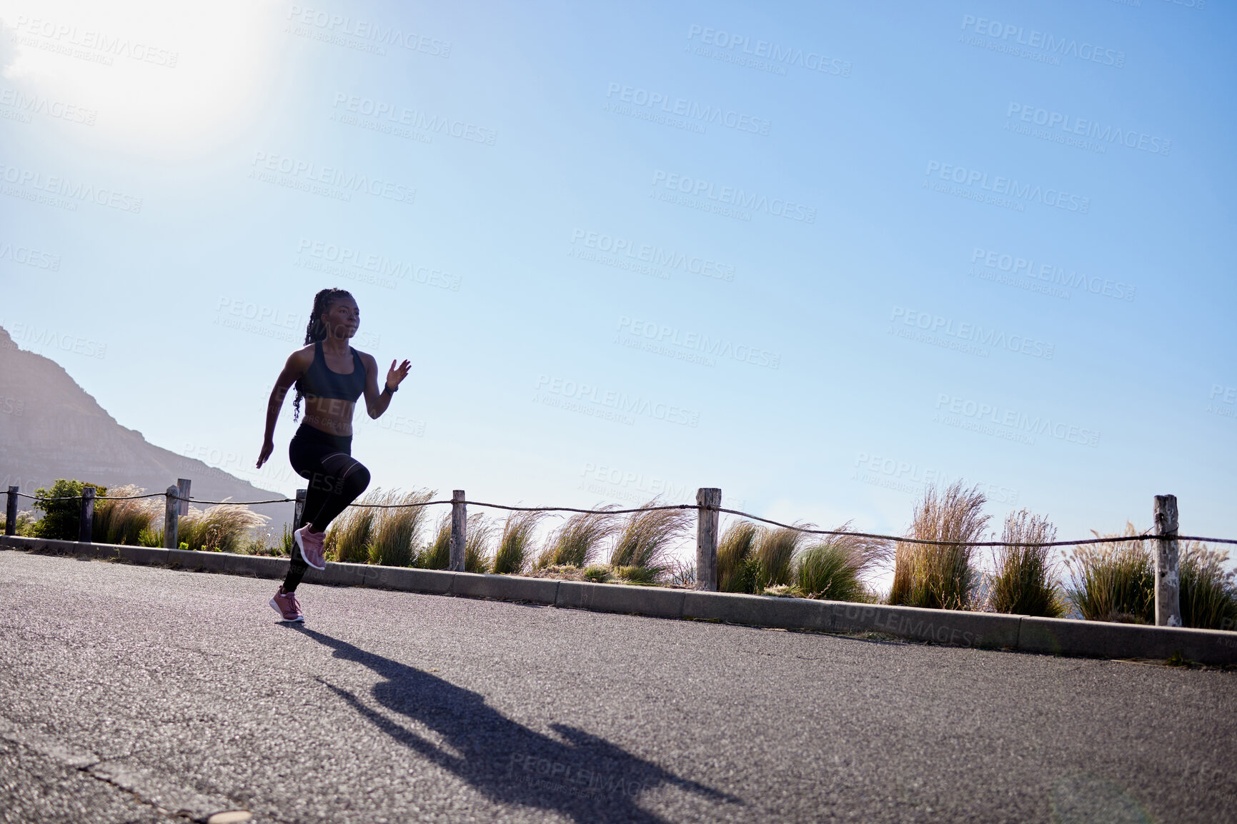 Buy stock photo One active young african american woman running outdoors. An athlete jogging to increase cardio and endurance during a workout in the morning. Determined to reach health, fitness and wellness goals