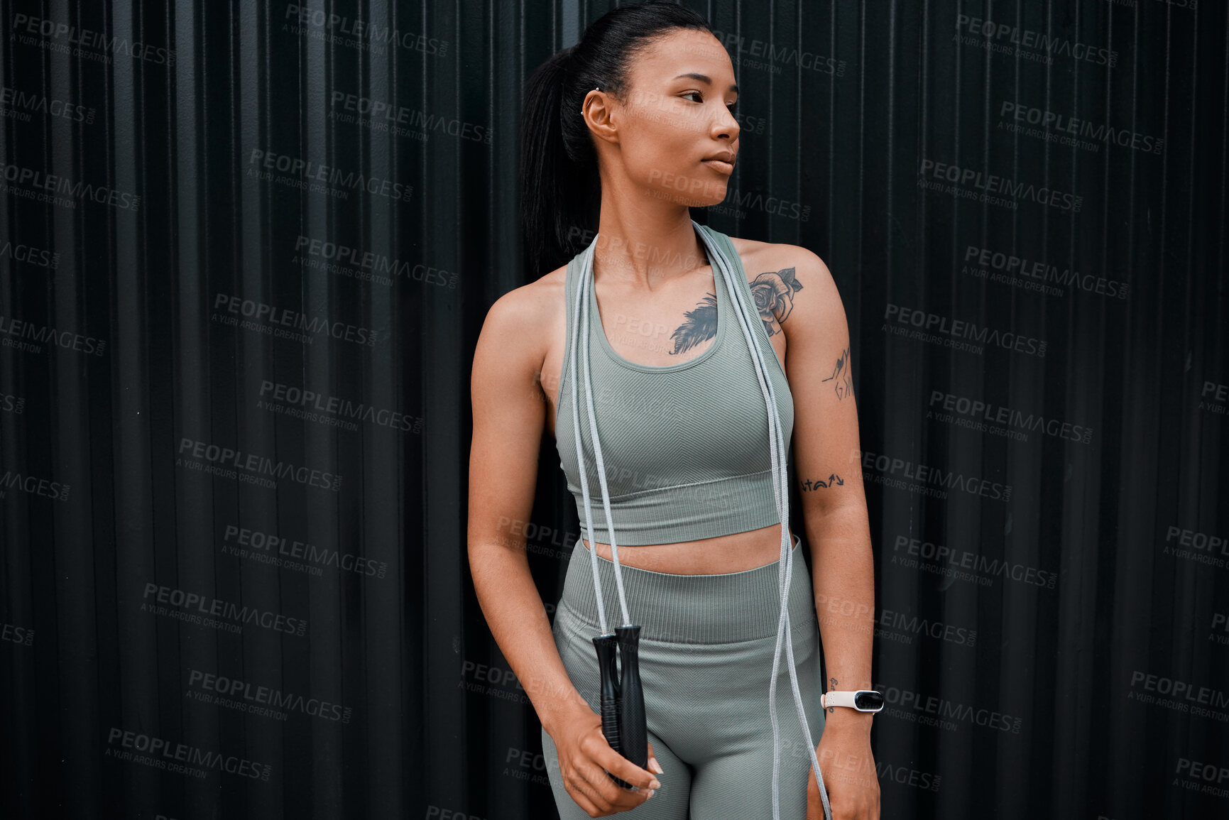 Buy stock photo Young mixed race hispanic female  wearing gymwear using a skipping rope while workout out outside in the city. Exercise is good for your health and wellbeing