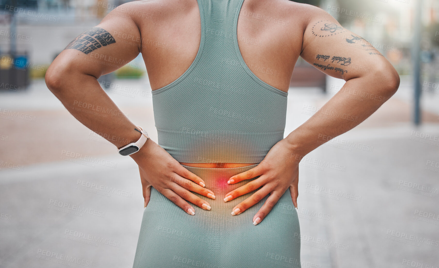 Buy stock photo Closeup shot of a young african american woman suffering with back pain while working out in the city. Superimposed cgi highlighting an injury where a female athlete is struggling with lower back ache