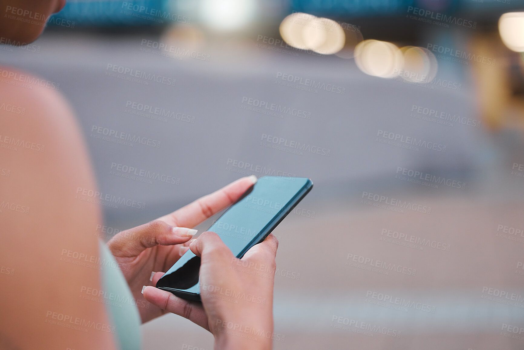 Buy stock photo Closeup shot of an unrecognizable woman taking a break from exercising outside in the city. Using a cellphone to check her text messages. Runner taking a break from training by scrolling social media 