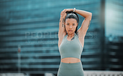 Buy stock photo Portrait of a young hispanic female athlete looking serious while stretching before exercising outside in the city. Young woman warming up her muscles against a urban background. Stretching is most important