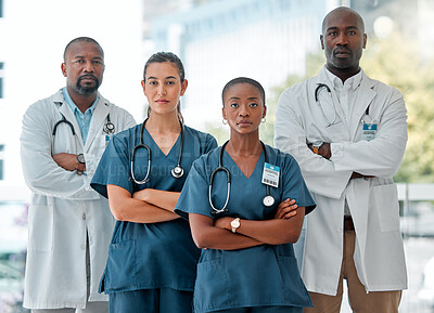 Group of serious diverse doctors standing in a line with their arms crossed while working at a hospital. Focused expert medical professionals at work together at a clinic