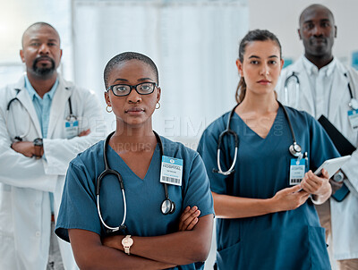 Group of diverse serious doctors standing with their arms crossed while working at a hospital. Expert medical professionals looking focused at work together at a clinic